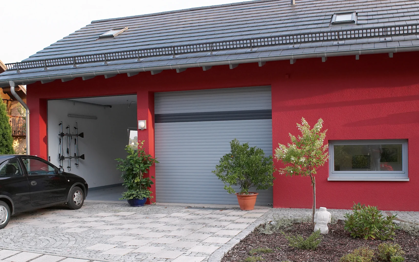 Doppelgarage mit einem geöffneten und einem geschlossenen Garagentor.