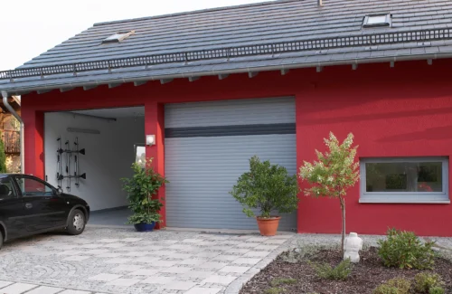 Doppelgarage mit einem geöffneten und einem geschlossenen Garagentor.