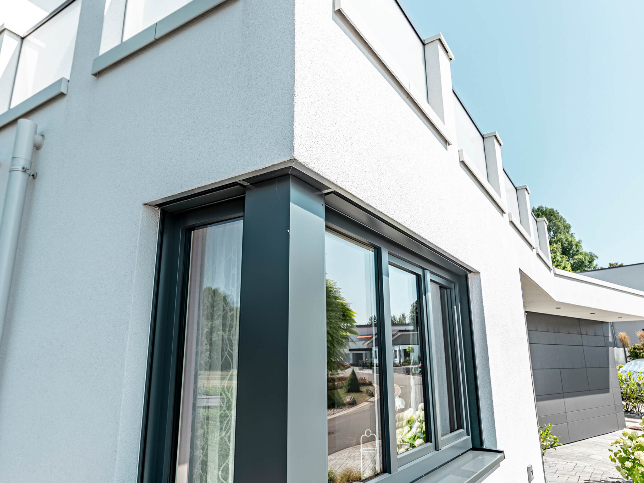Stilvolle Außenterrasse mit Lamellendach und Beleuchtung Hausecke mit Aluminiumfenster mit dunklem Aluminiumrahmen